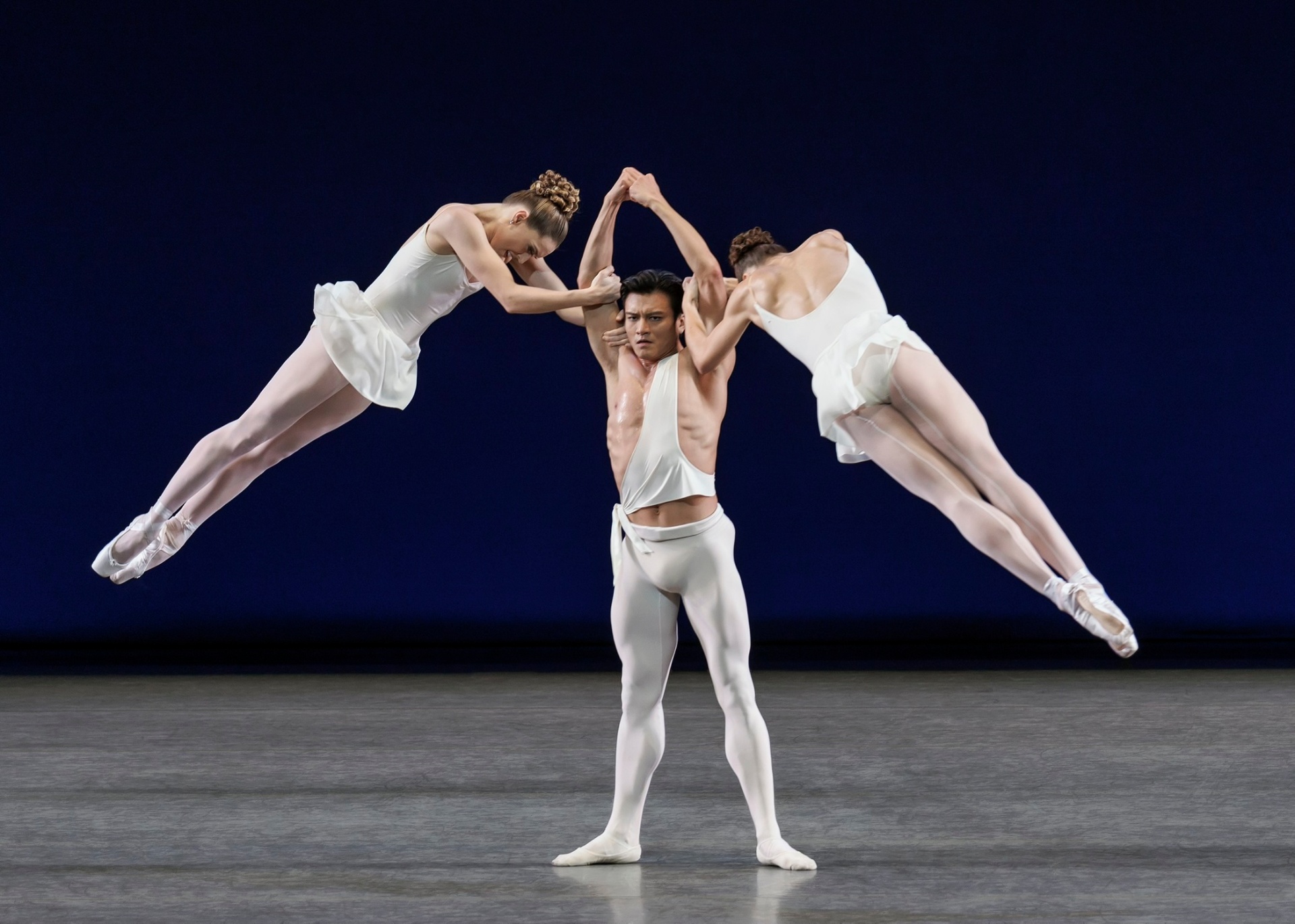 Apollo series — Apollo — flanked by two muses suspended mid-leap against deep blue