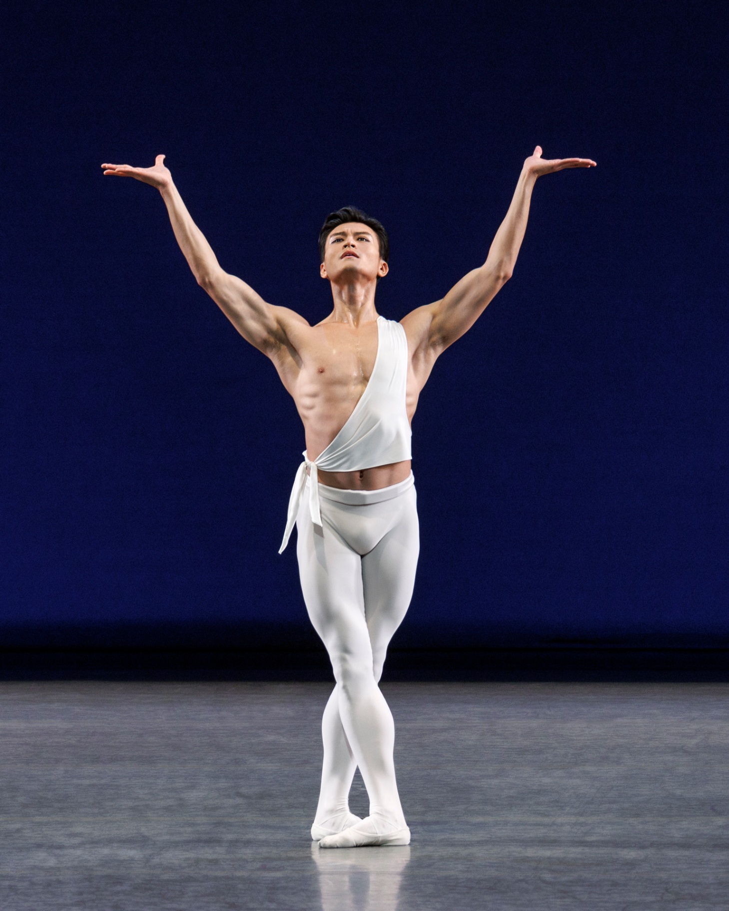 Apollo series — Apollo — solo with arms outstretched in offering against deep blue