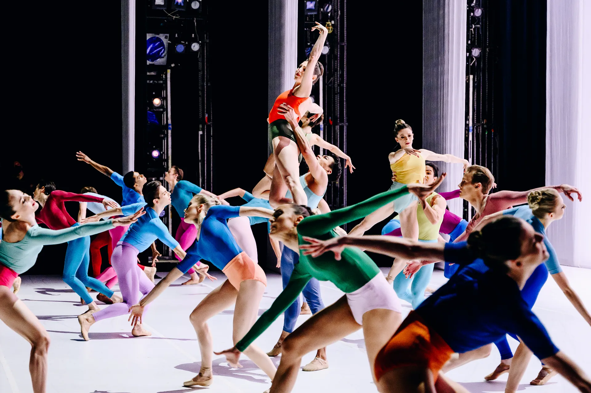 Copland Dance Episodes series — Copland Dance Episodes — ensemble in vibrant colors mid-motion with overhead lift